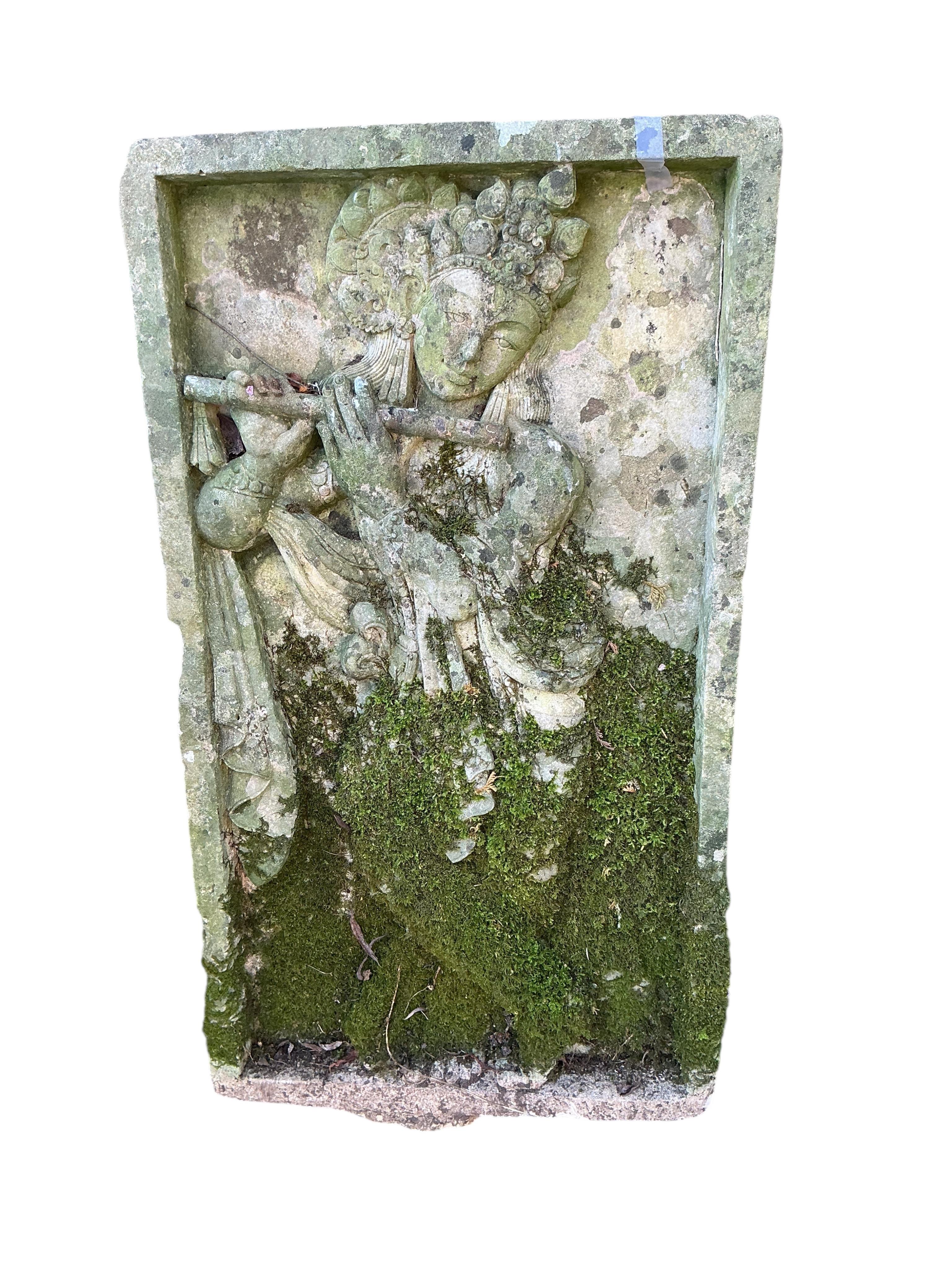 A reconstituted stone relief panel of Krishna playing the flute, width 50cm, height 90cm